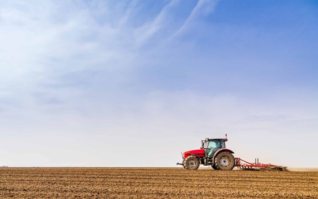 Farmer in tractor preparing land with seedbed cultivator