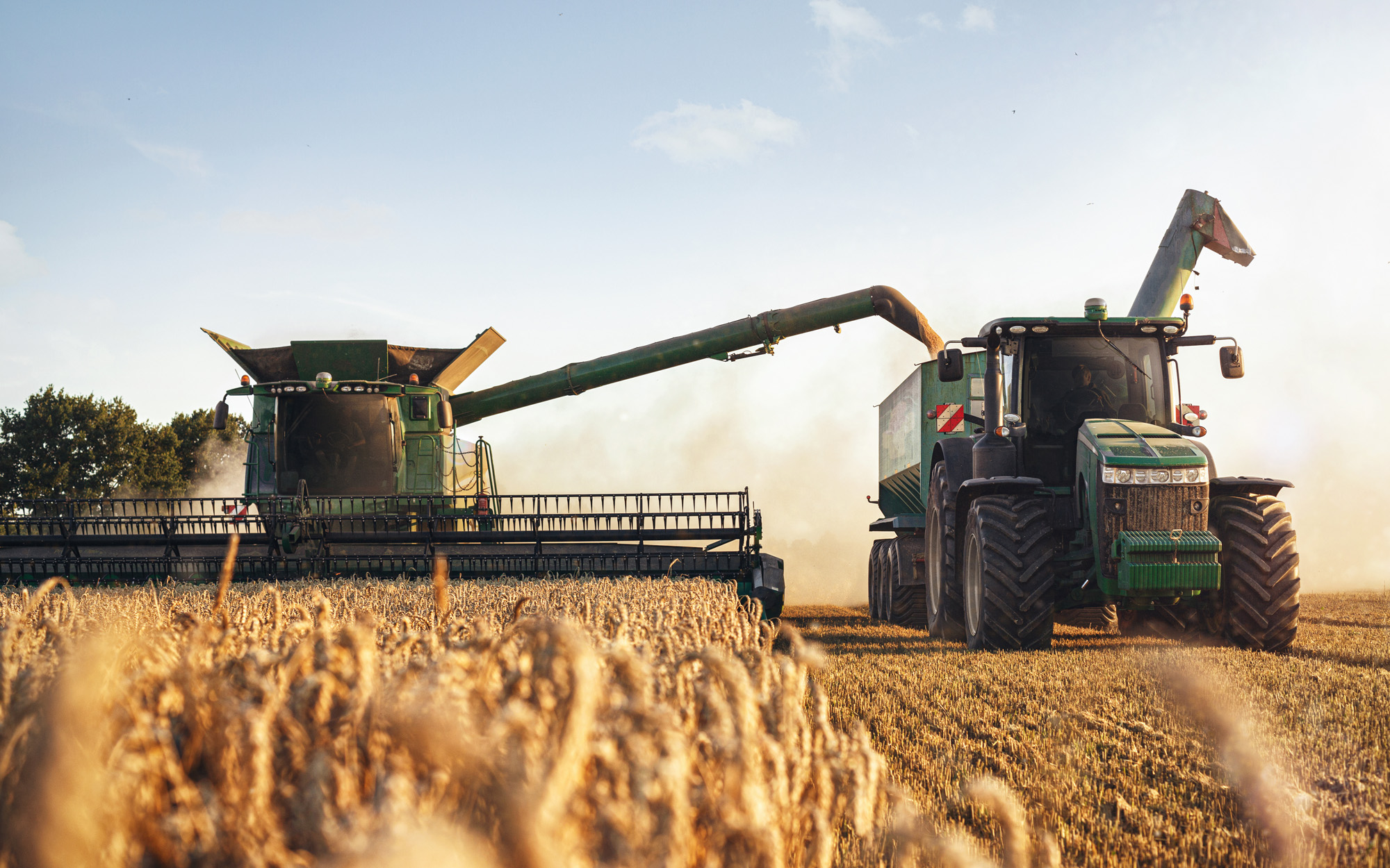 combine harvester and tractor in field